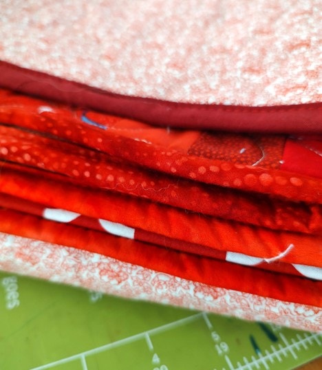 Close up of the Binding with the Scrappy Patriotic Log Cabin Star Quilt Folded Up