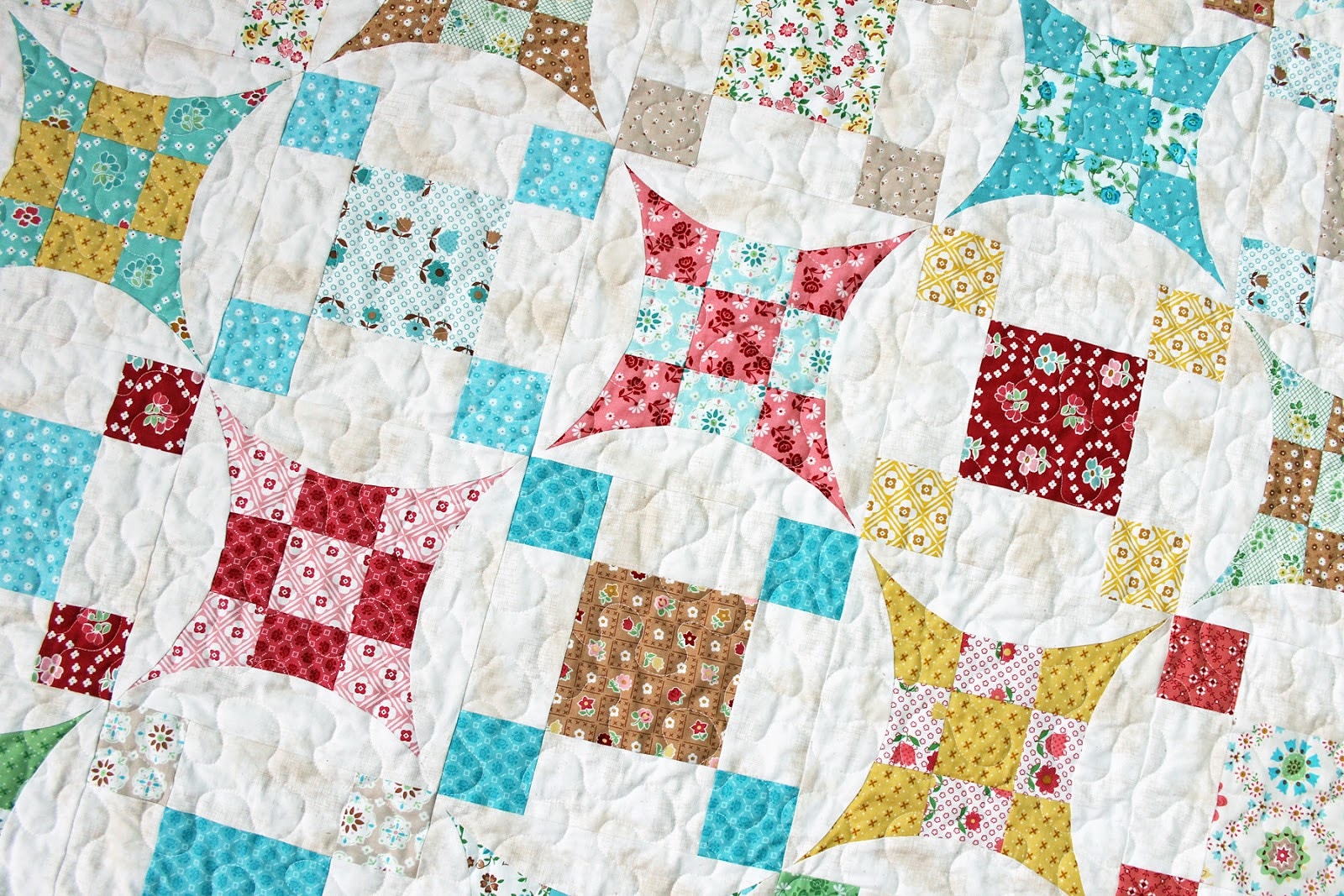 Glorified Nine Patch quilt with red, gold, teal and white fabric.