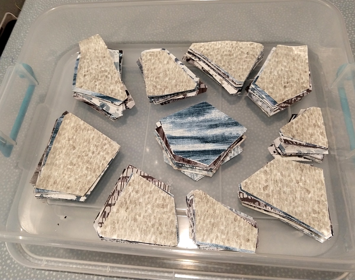 AccuQuilt GO Crazy Quilt block pieces cut and organized in plastic tub
